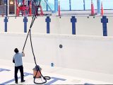 Commercial high dusting technician cleaning elevated surfaces in a Whitehorse recreation facility